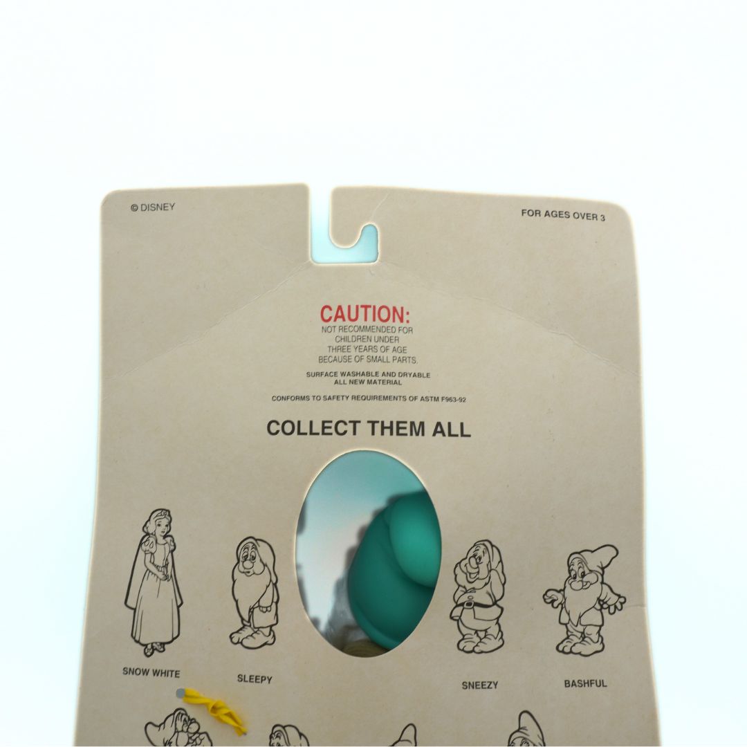 Toy packaging on a vintage 1994 Snow White toy with its green hat visible