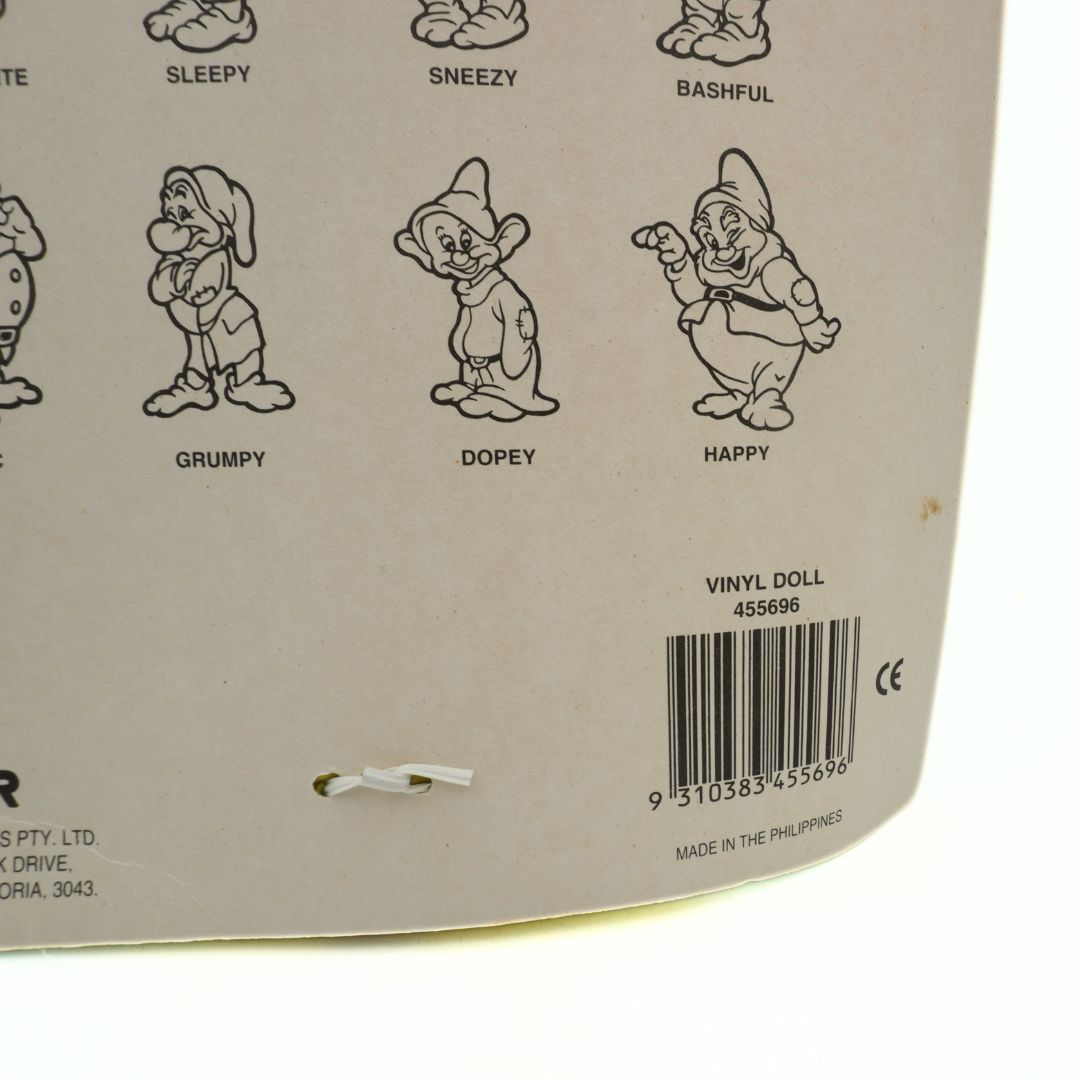 Back of a vinyl doll packaging with seven dwarfs illustrations and a barcode.