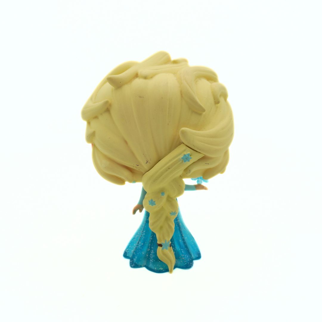 Toy figure with blonde hair and blue dress on a white background