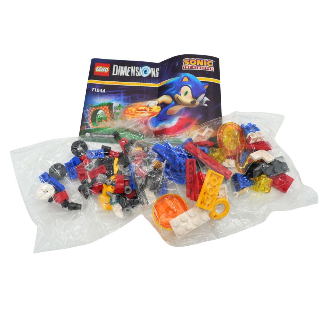 Lego Dimensions Sonic Universe 71244 building set contents, showing the product box featuring Sonic the Hedgehog and two clear plastic bags filled with assorted toy bricks, studs, and accessories on a white background.