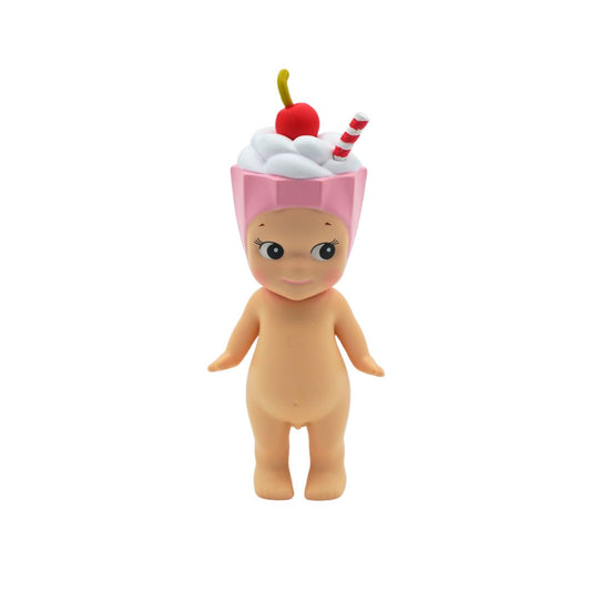 A Sonny Angel with a pink cherry milkshake on its head, photographed against a white backdrop.