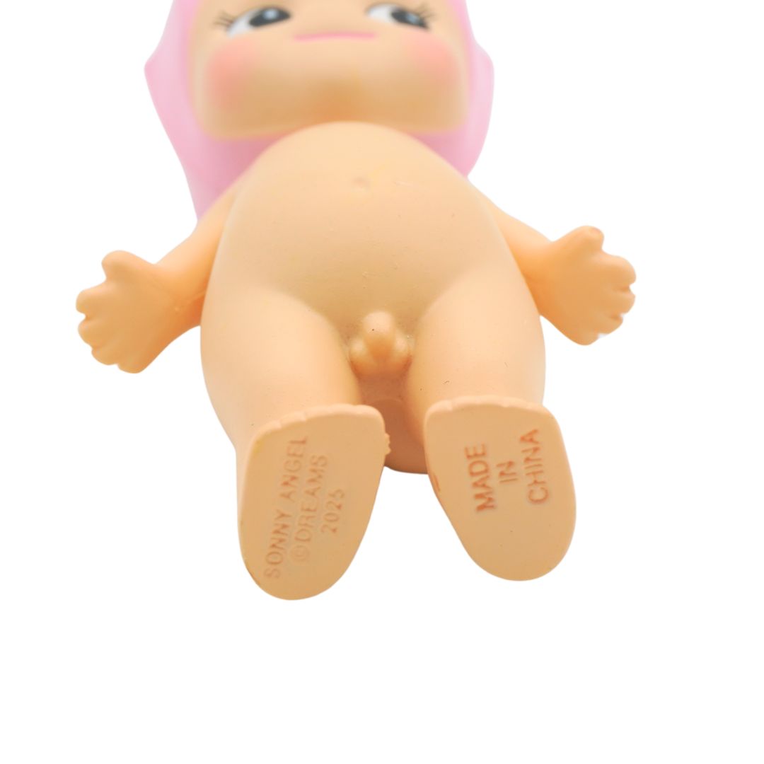 A Sonny Angel with a pink cherry milkshake on its head, photographed against a white backdrop.