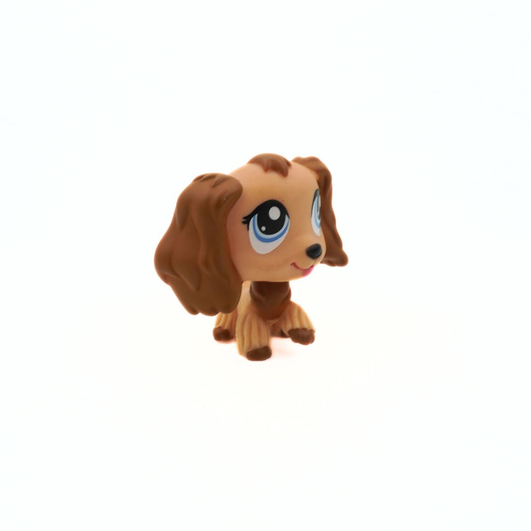 Small brown dog figurine with large blue eyes on a white background
