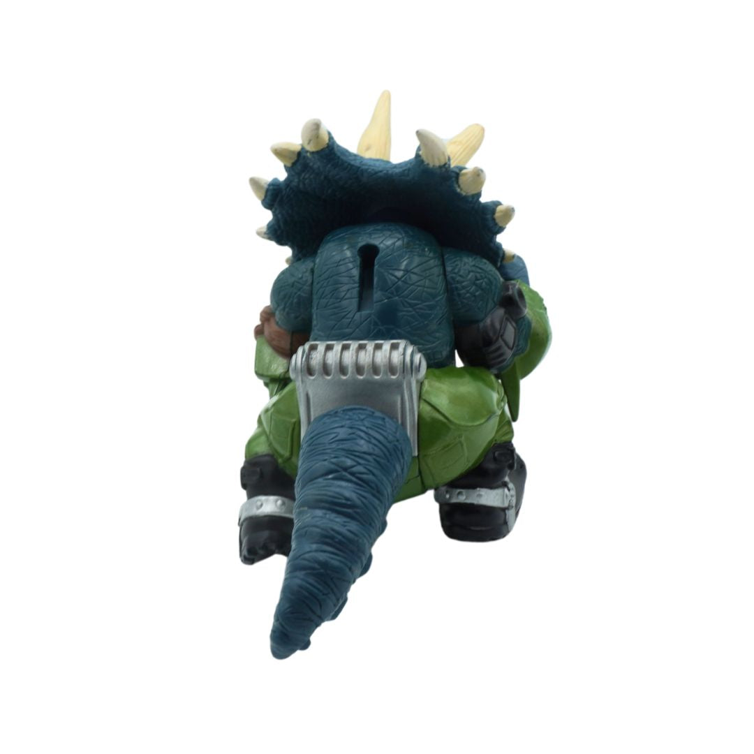 Toy figure of a creature with green body, blue feet, and spikes on a white background