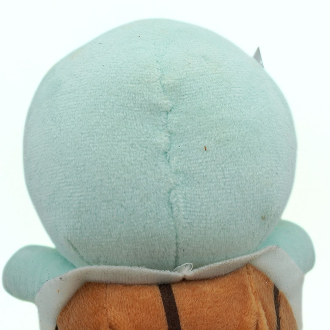 Close-up of a plush toy with a light blue head and brown body on a white background
