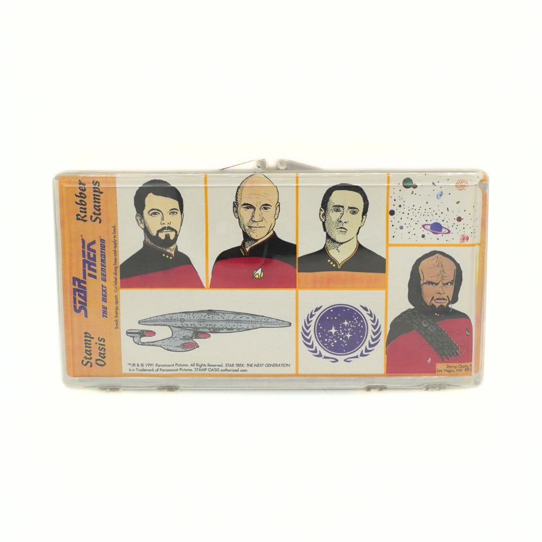 Star Trek rubber stamps collectible set in a clear plastic case, featuring illustrations of Kirk, Spock, and Picard, the Enterprise, and space-themed graphics.