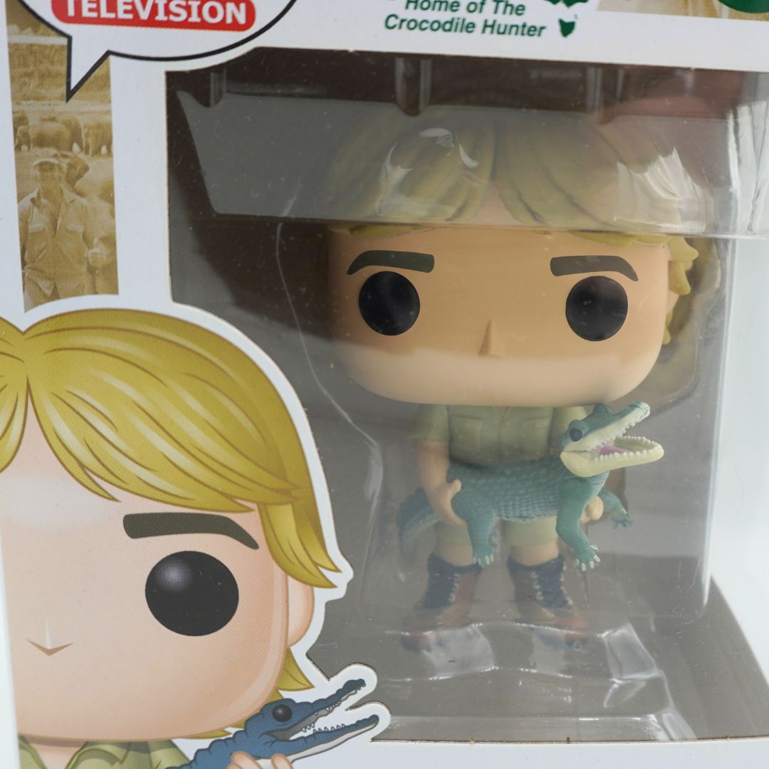 Closeup of a Pop Television Funko Pop of Steve Irwin, wearing a green outfit and holding a crocodile