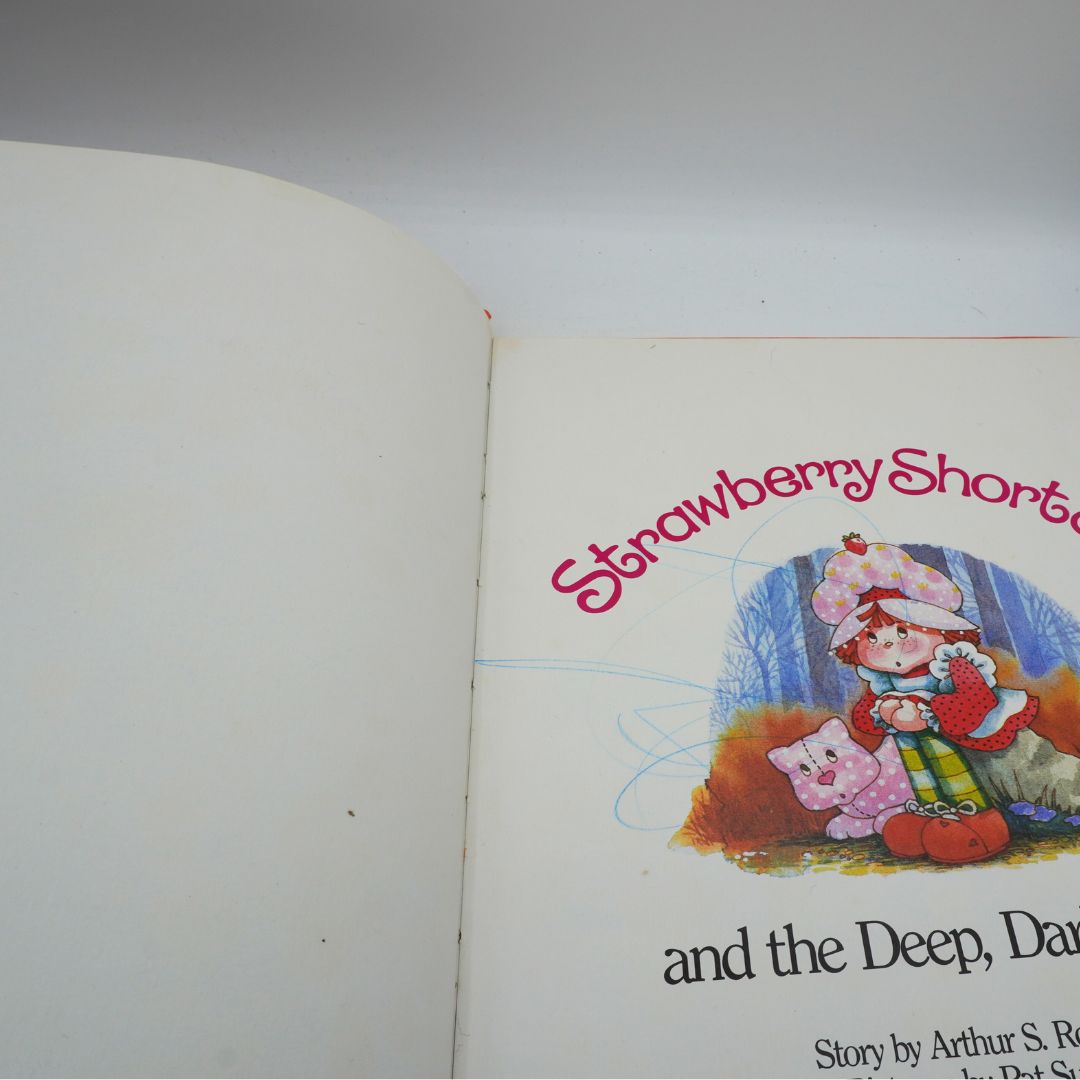 Open book with 'Strawberry Shortcake' illustration on a white background