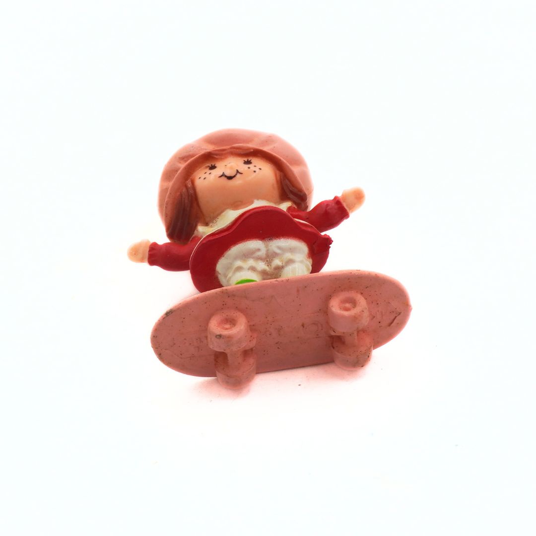 Toy figure of a child on a skateboard with a white background