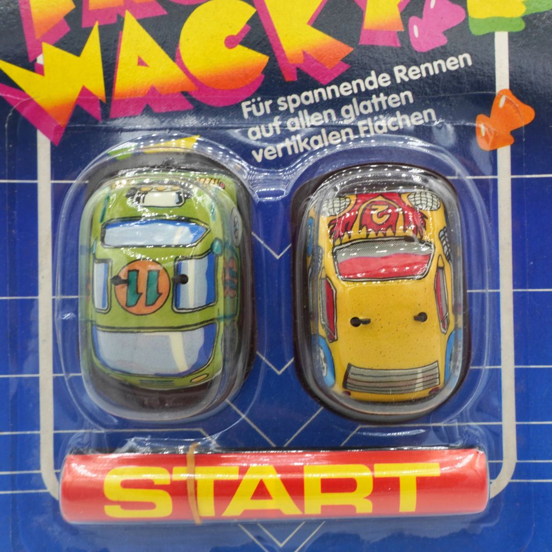Two toy cars in packaging with 'Start' button on a blue grid background