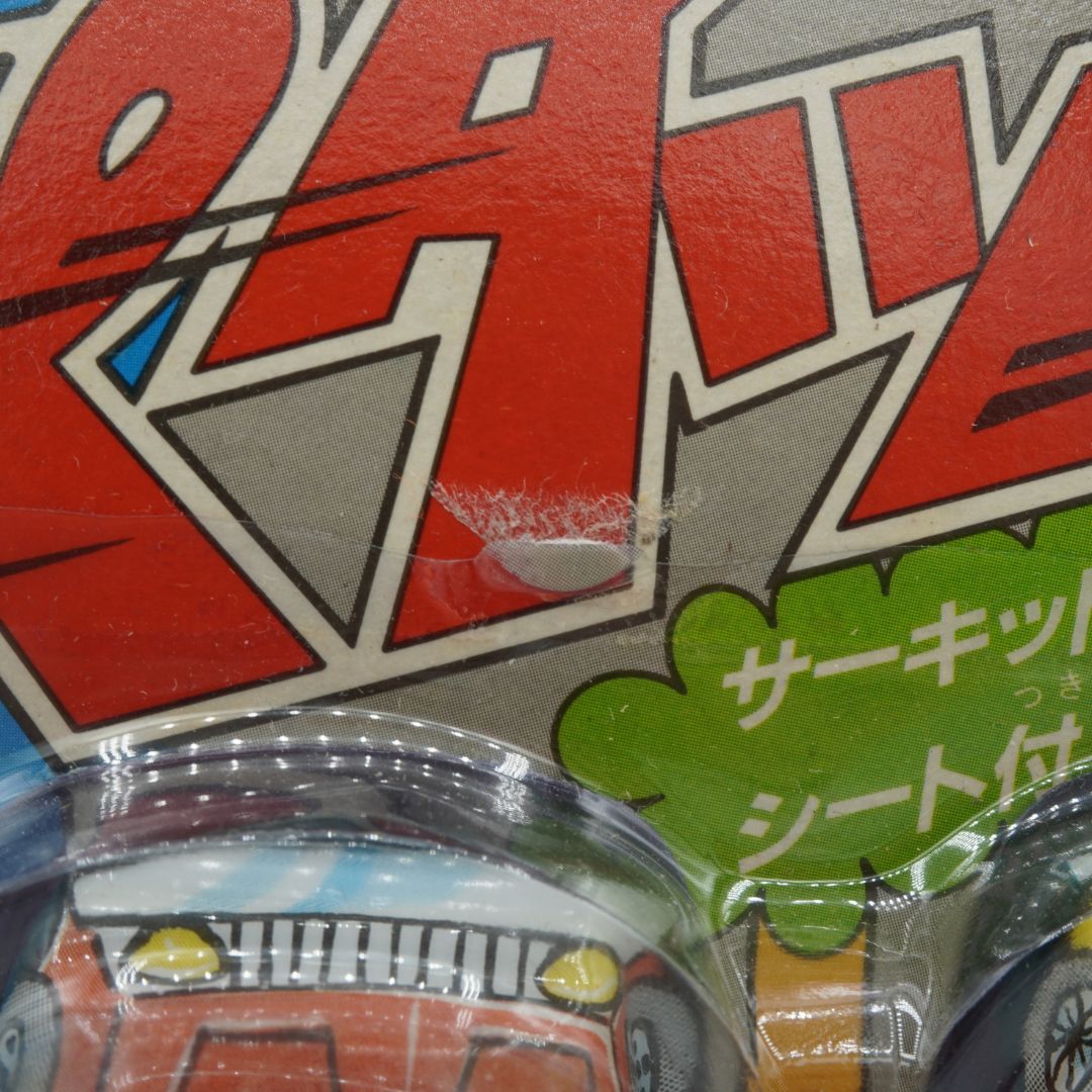 Close-up of a toy car packaging with Japanese text and graphics.