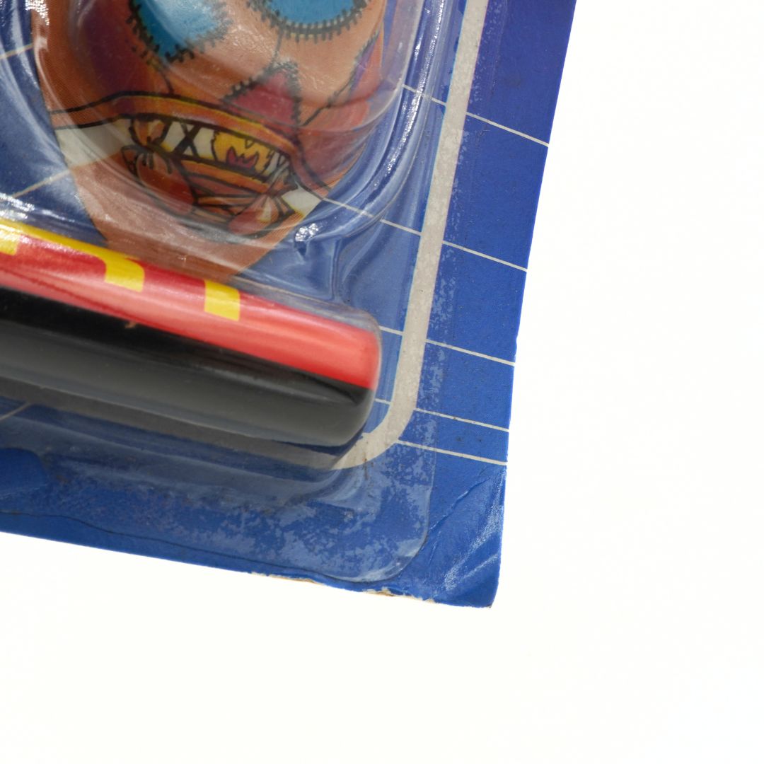 Colourful toy on blue cardboard with grid lines