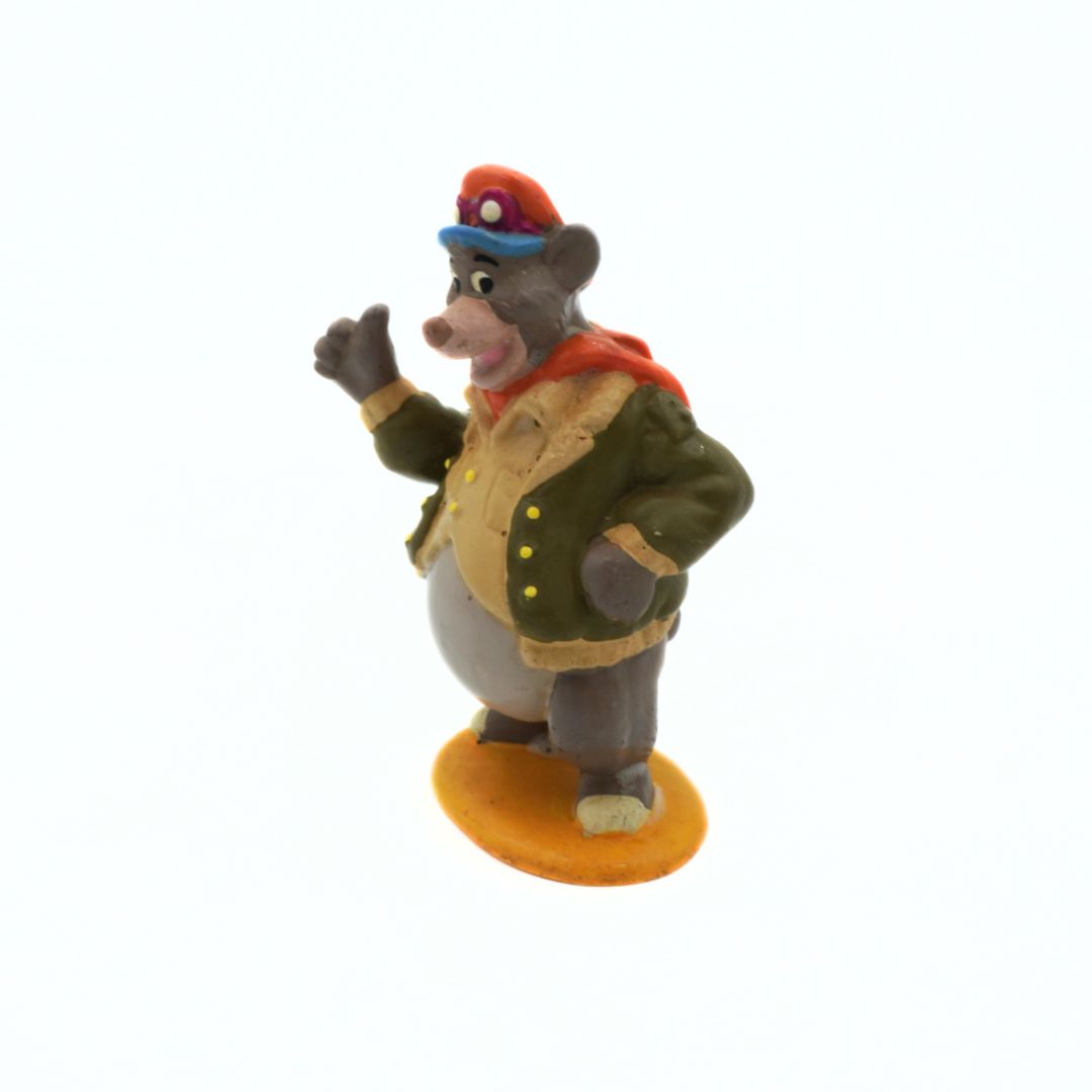 Animated character figurine in a green coat and red hat on a white background