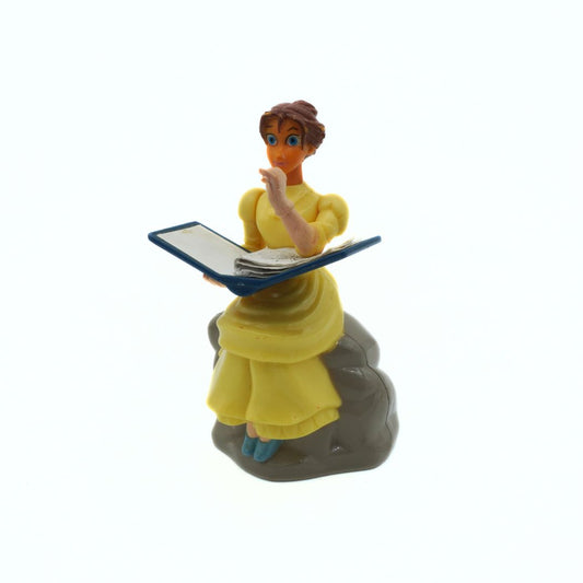 Figurine of a character in a yellow dress holding a book on a white background