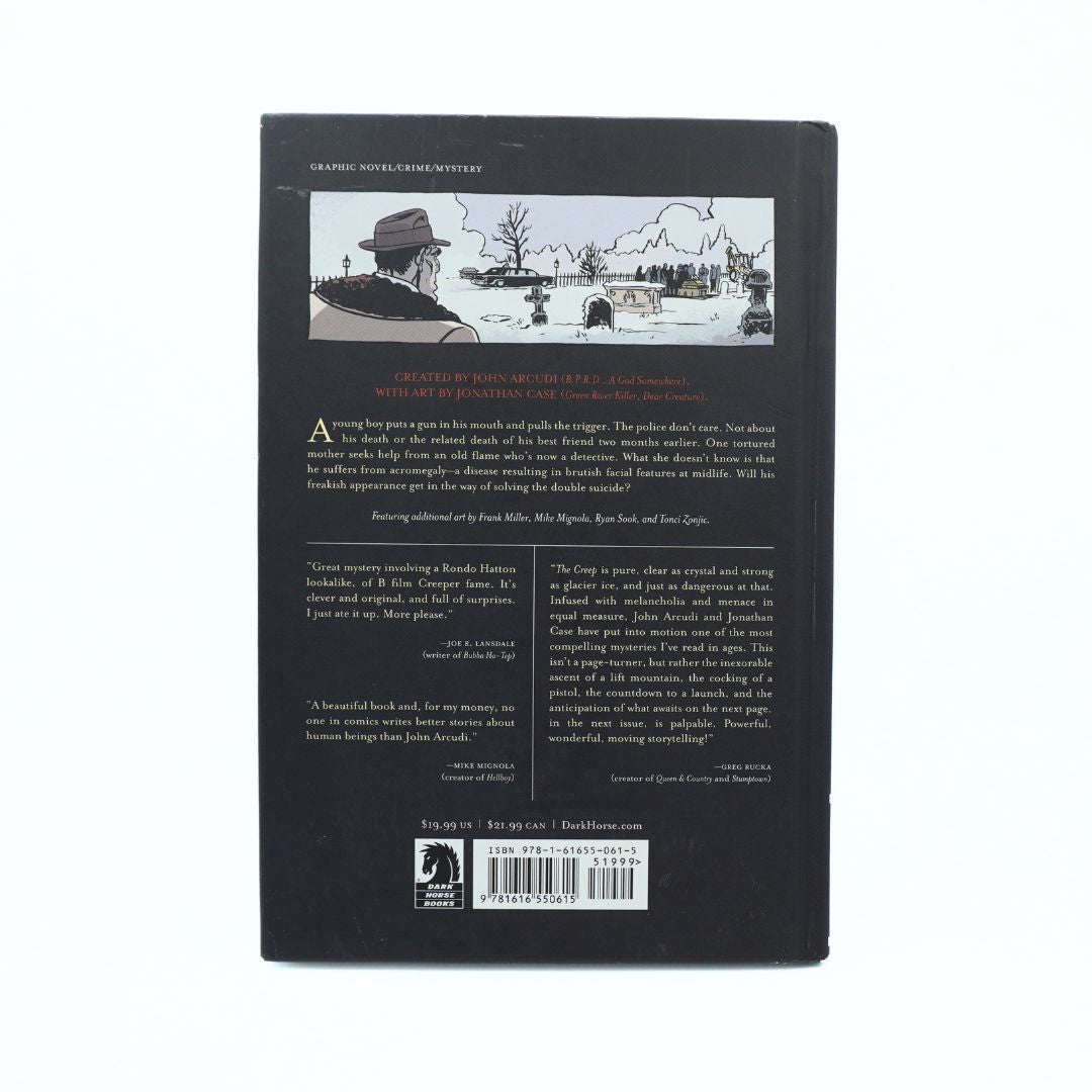 The back cover of the book 'The Creep' on a solid white background. The cover is black with a white and red illustration of a man in a hat overlooking a lake, along with text and a barcode at the bottom.