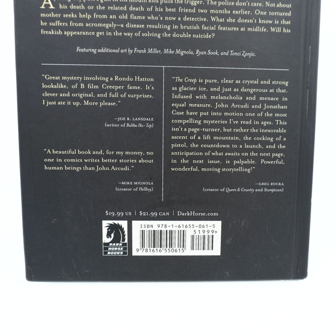 The back cover of a book, photographed flat against a white background. The cover is predominantly black with white text, featuring book reviews, a barcode, and the Dark Horse publisher logo at the bottom.