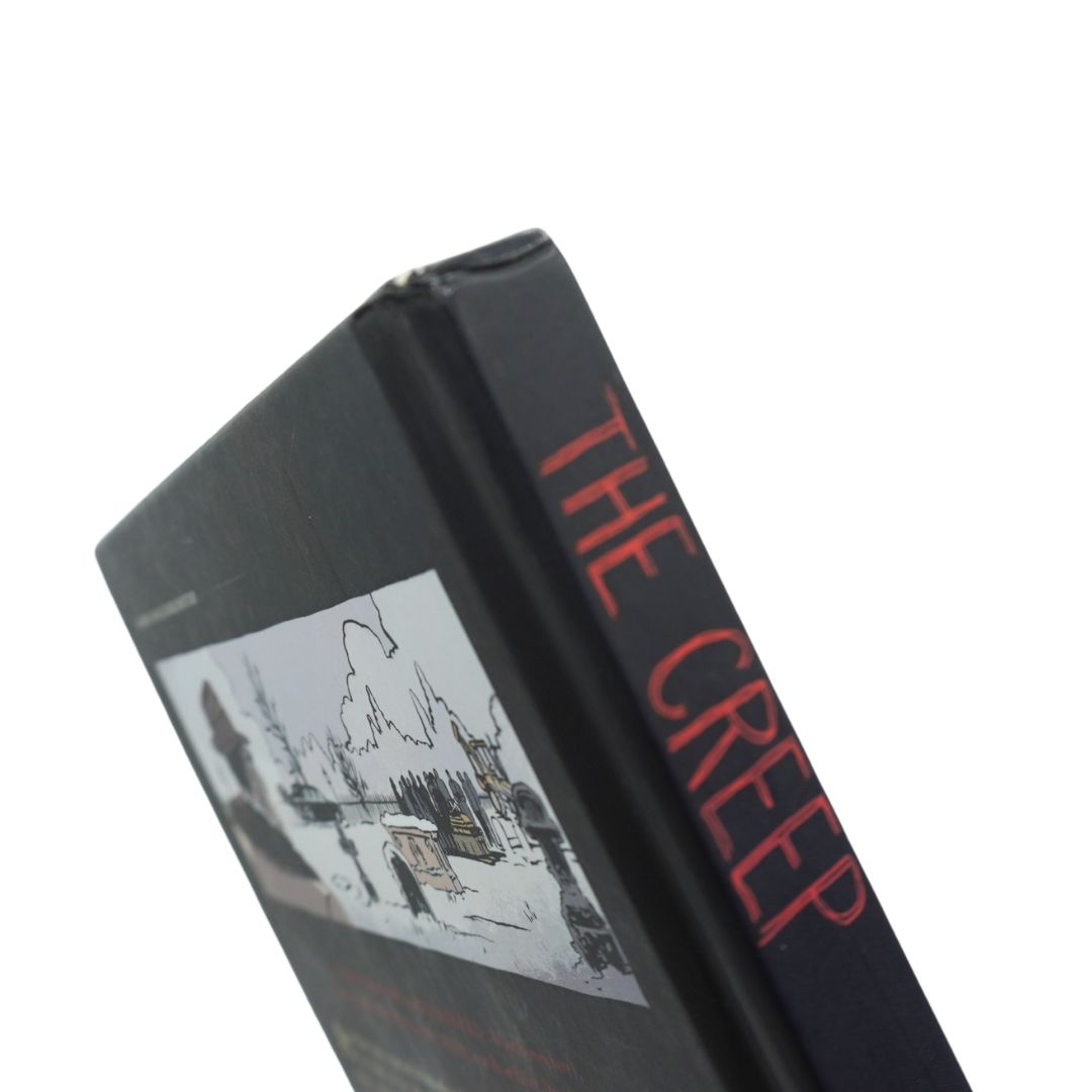 A close-up angled shot of a hardcover book titled 'THE CREEP' on a plain white background. The book spine is black with the title in red, and the front cover features a black-and-white illustration.