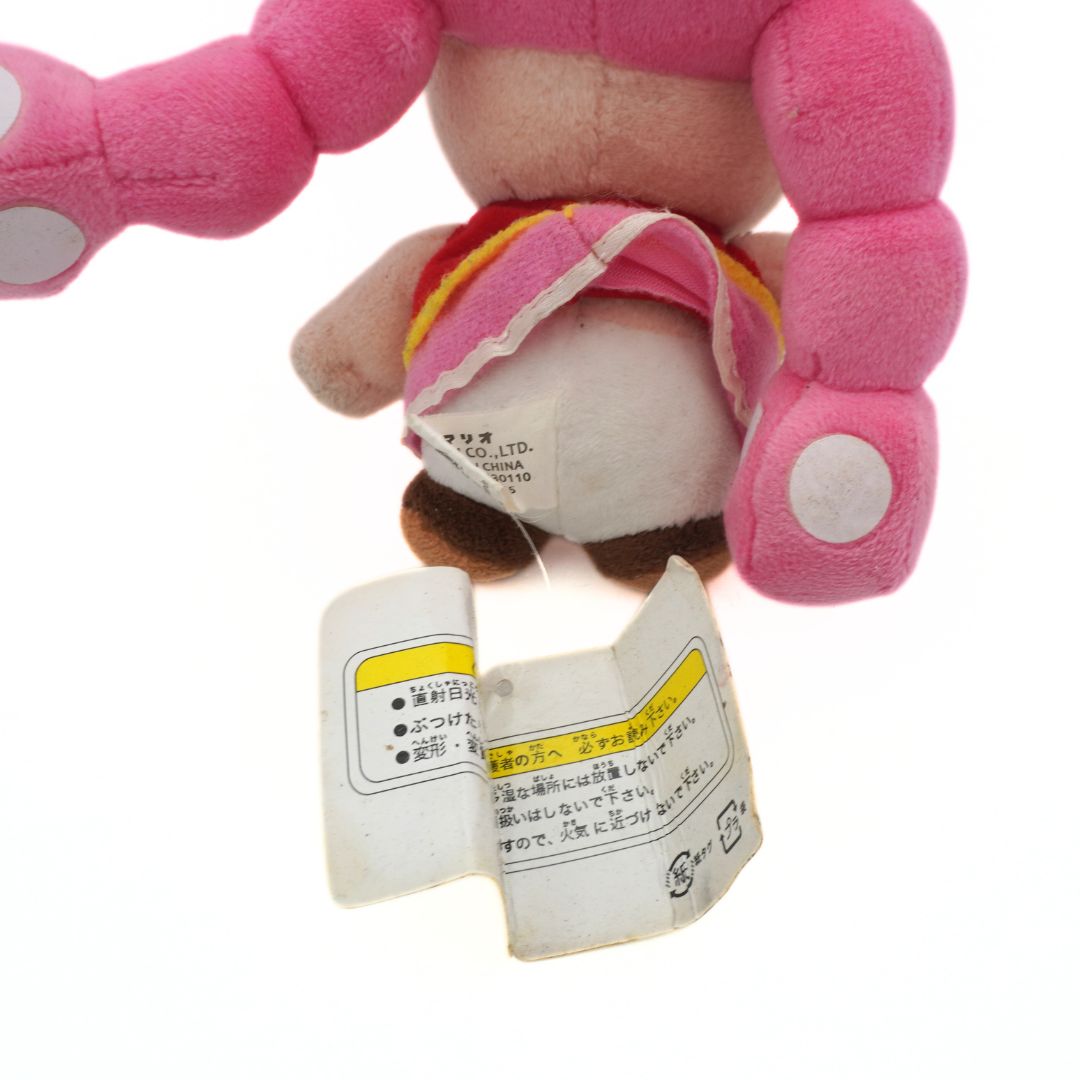 Plush toy with a label attached on a white background