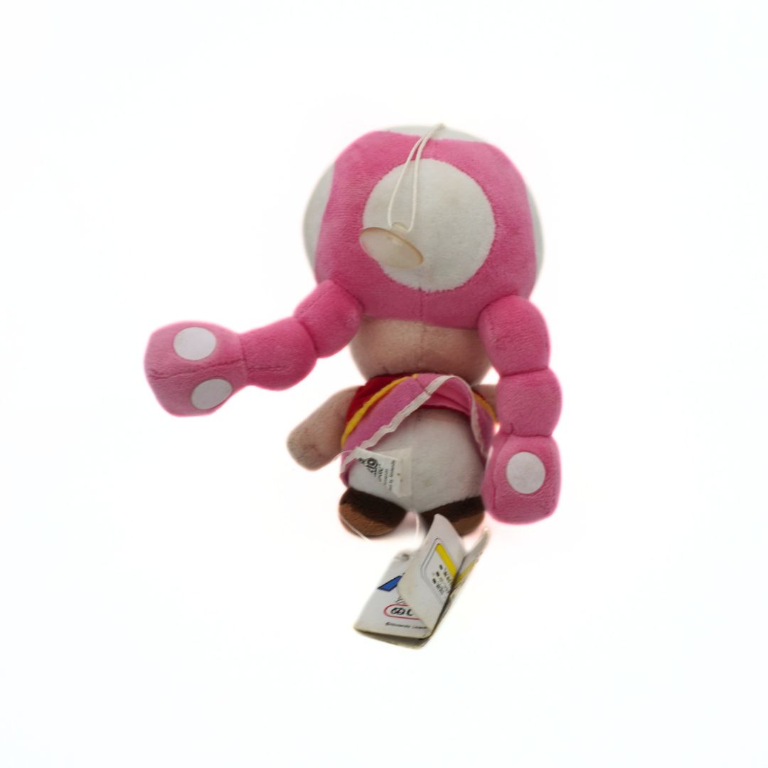 Pink plush toy with a tag on a white background