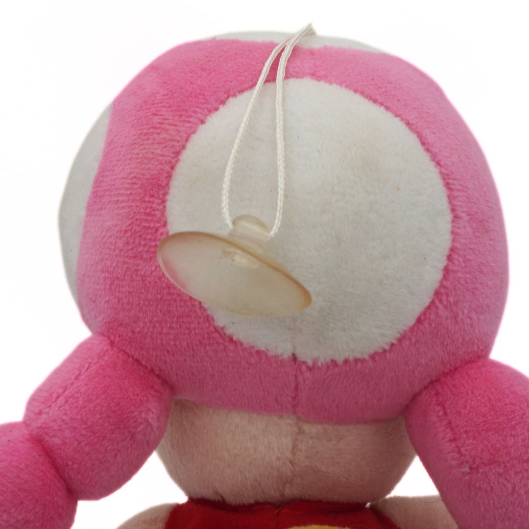 Close-up of a pink plush toy with a white face on a white background