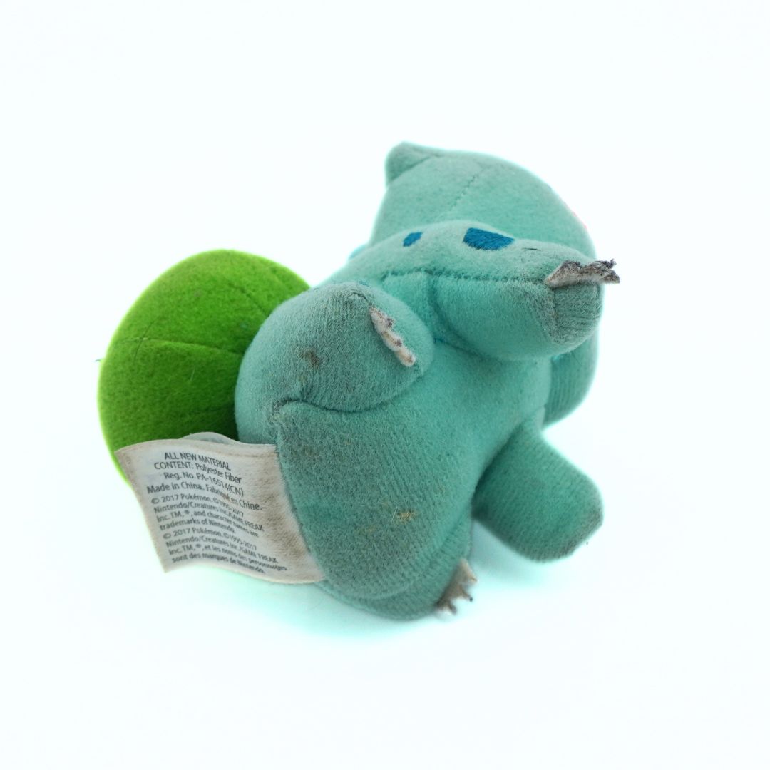 Green plush toy with a label on a white background