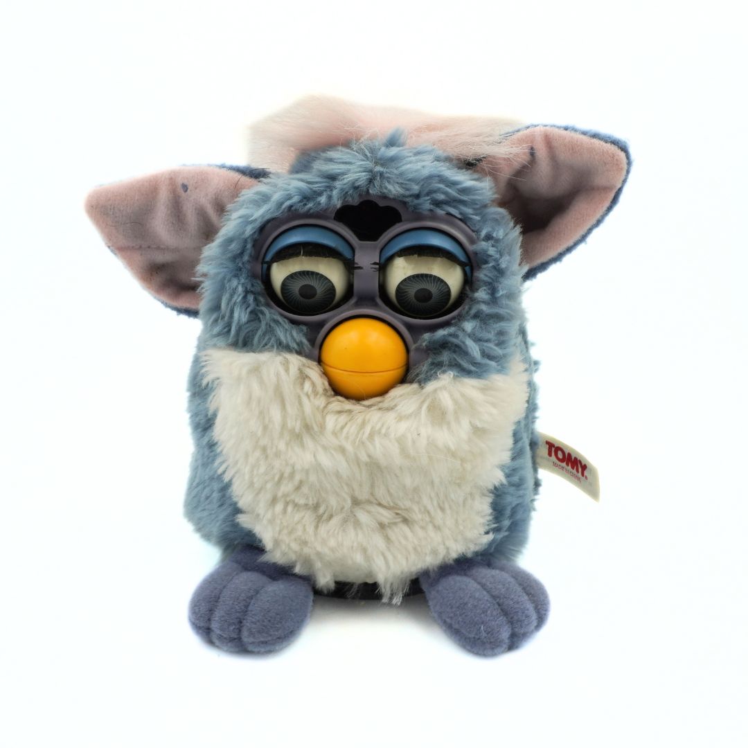 Plush toy resembling a character with large eyes and an orange mouth on a white background