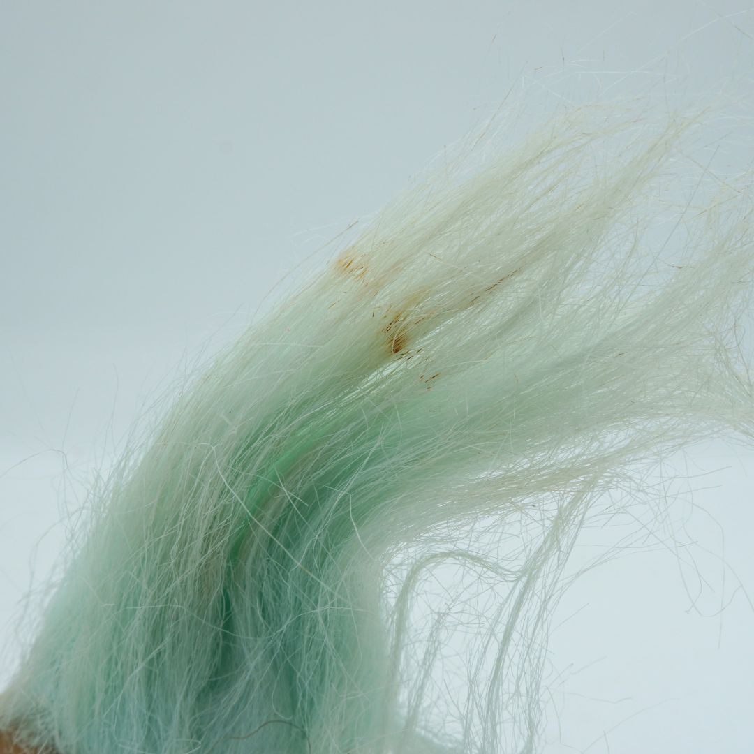 Close-up of green synthetic hair on a white background