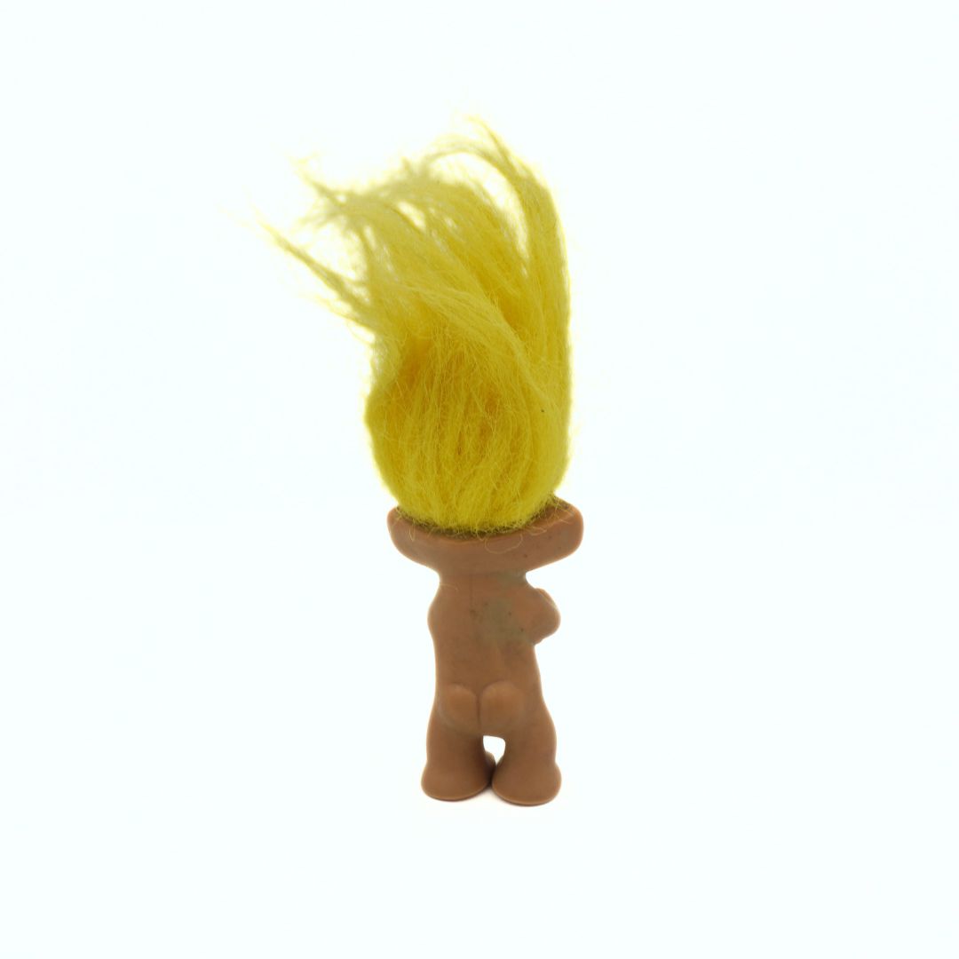 Small figurine with yellow hair on a white background
