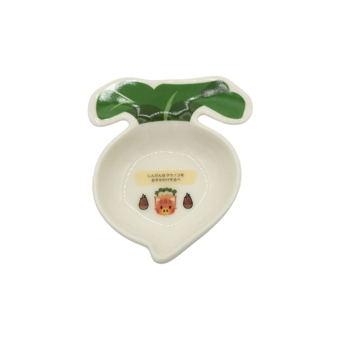 A white and green turnip shaped plate featuring a pig carrying a load of turnips, photographed against a white background.