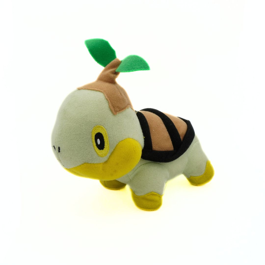 Plush toy resembling a turtle with a leaf on its head on a white background