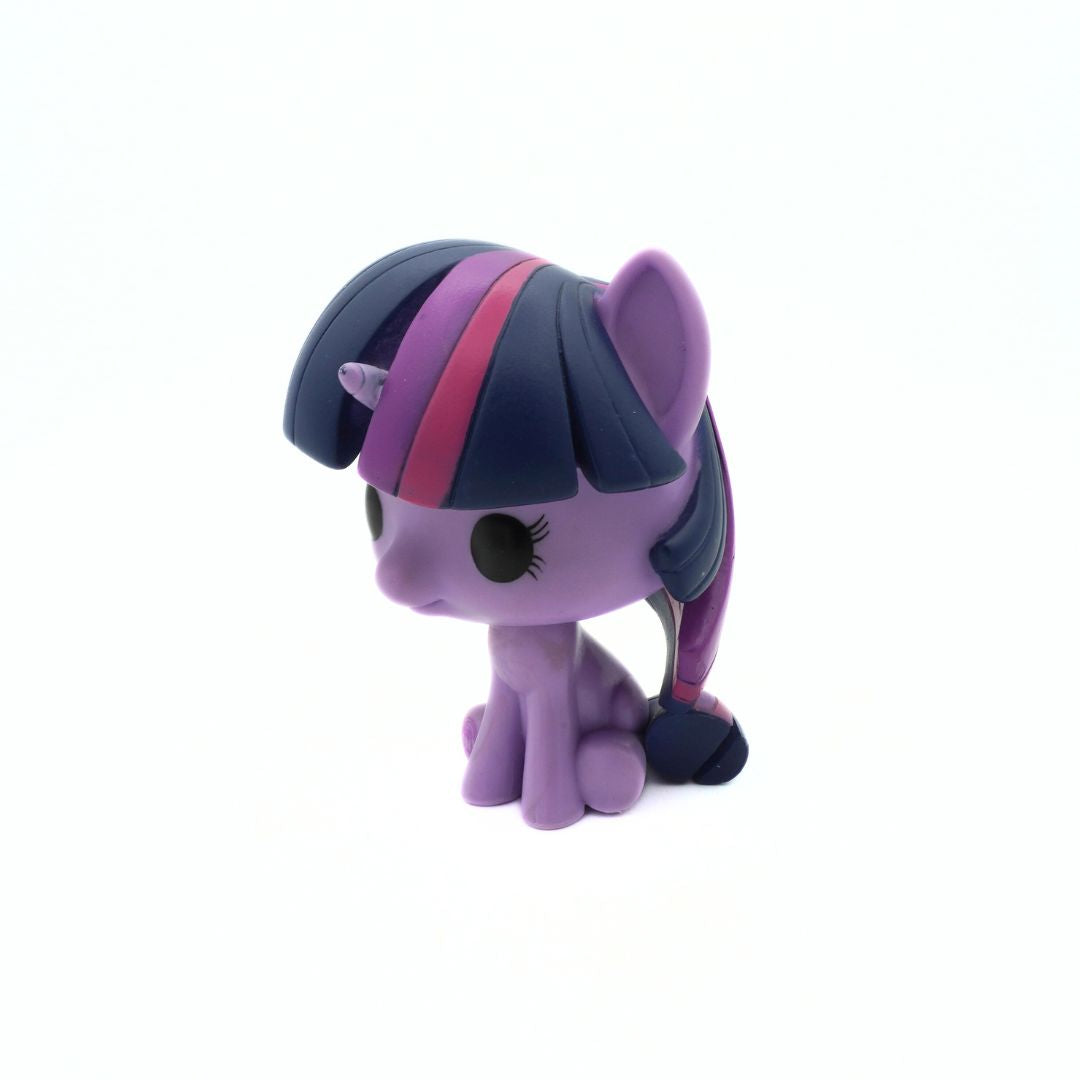 Small purple toy pony with a blue mane and pink stripe on a white background
