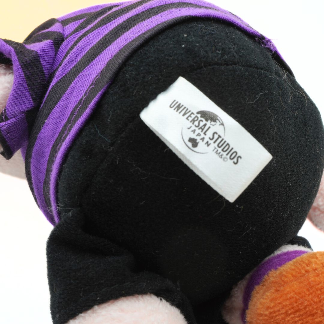 Black plush toy with a purple hat and orange item, featuring a Universal Studios Japan tag.