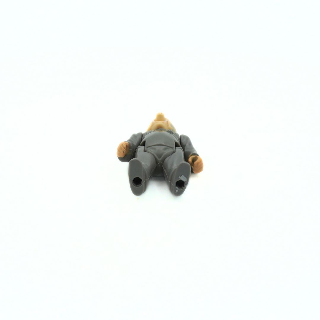 Small toy figure of a person lying down with a hat on a white background