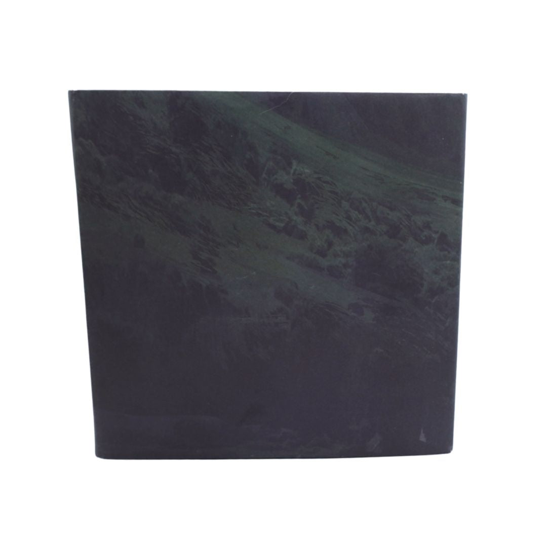 A square art print or book cover featuring a moody, dark landscape painting of a green and black mountain slope, shown against a plain white background.