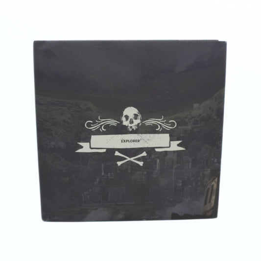A square black box featuring a white skull and banner graphic with the word 'EXPLORER' on a dark scenic background, photographed against a plain white backdrop.