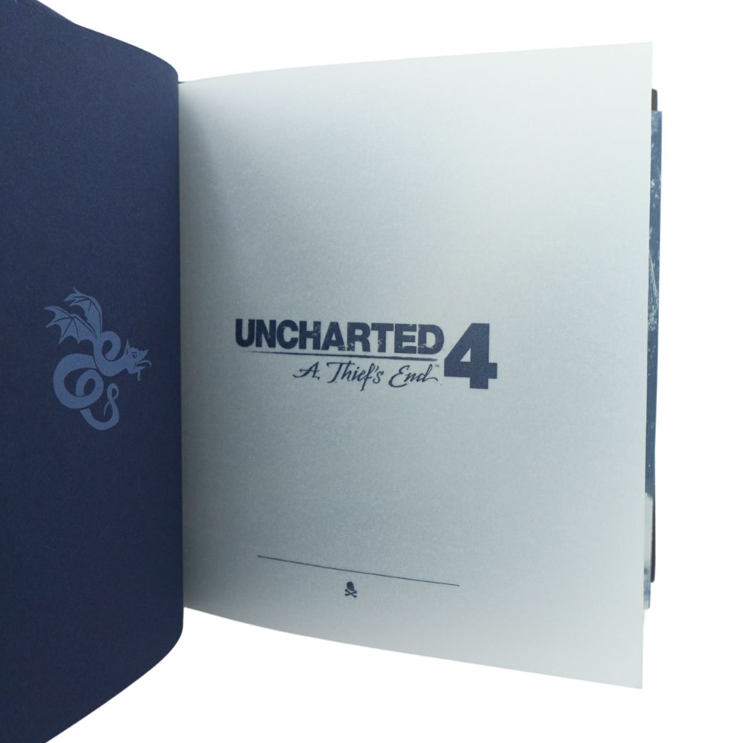 An open collectible book or album showing the cover on the left in dark navy blue with a dragon graphic, and the inner page on the right printed with 'UNCHARTED 4: A Thief's End 4' in dark blue text on a white background.
