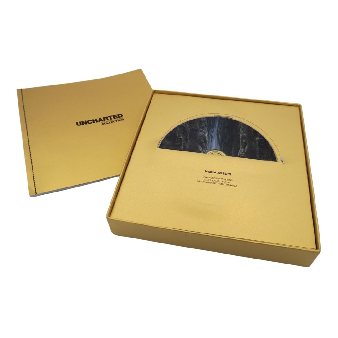Uncharted 4: The Game's Media Assets package, featuring a gold-colored presentation box with its lid off, revealing a CD-ROM disc inside a half-circle cutout, alongside the branded outer sleeve.