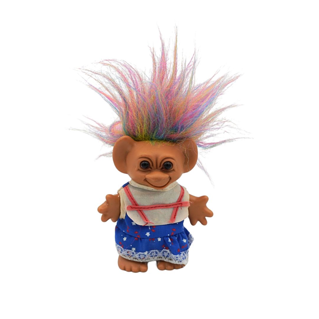 Vintage rainbow haired Troll with brown eyes and a blue dress, released by Uneeda