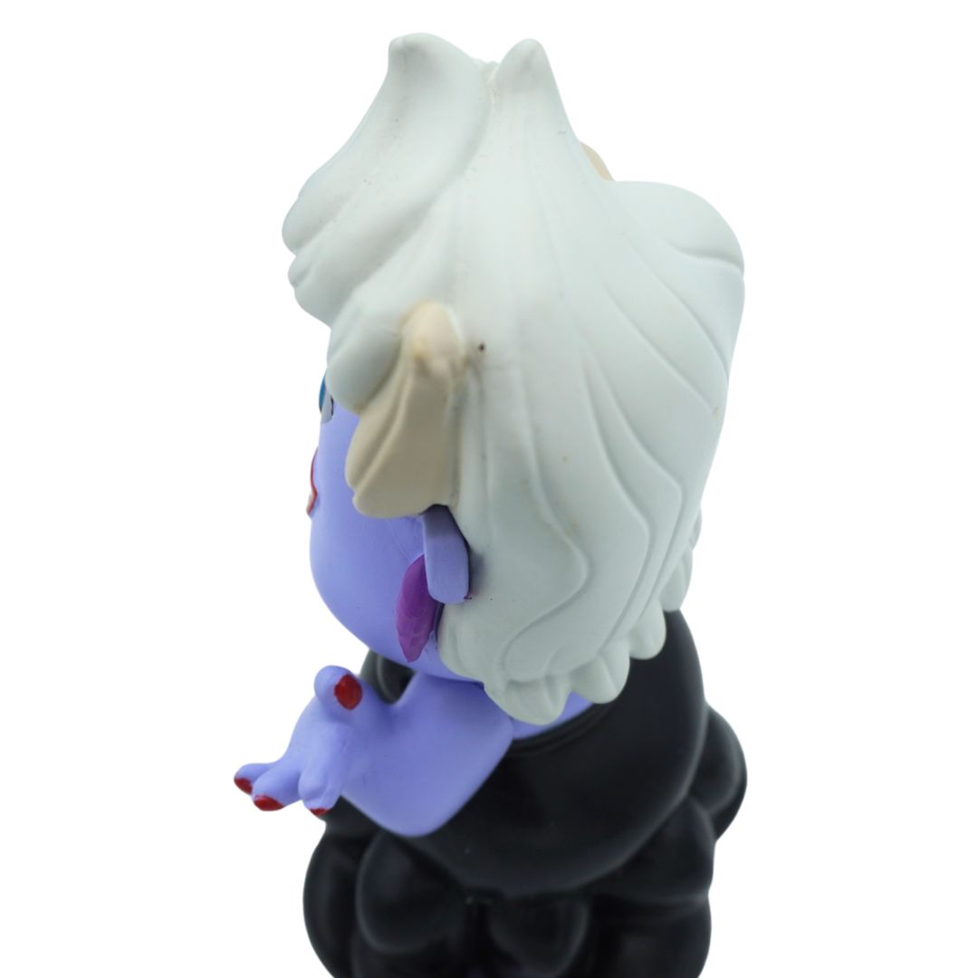 A stylized vinyl figure of a purple-skinned character with long white hair, cream-colored horns, and a black outfit, shown from a side-back angle on a plain white background.