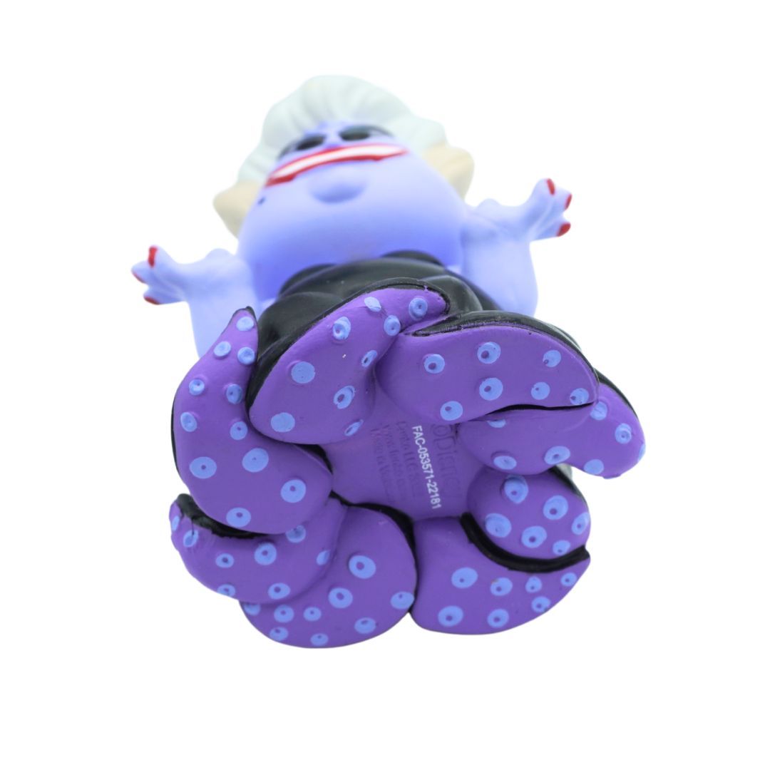 A small vinyl or rubber figurine of a blue creature with white hair, red lips, and purple tentacle-like feet with blue spots, shown on a plain white background.