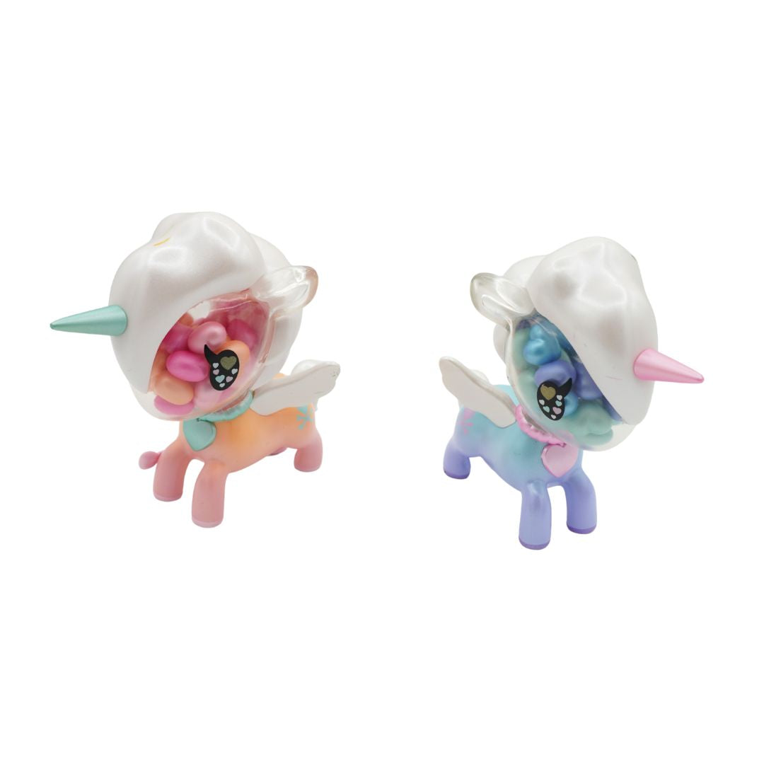 Two small pastel unicorn figurines with white horned helmets and wings, shown side by side on a plain white background. One unicorn is pink, peach, and mint, and the other is blue, lavender, and pink.