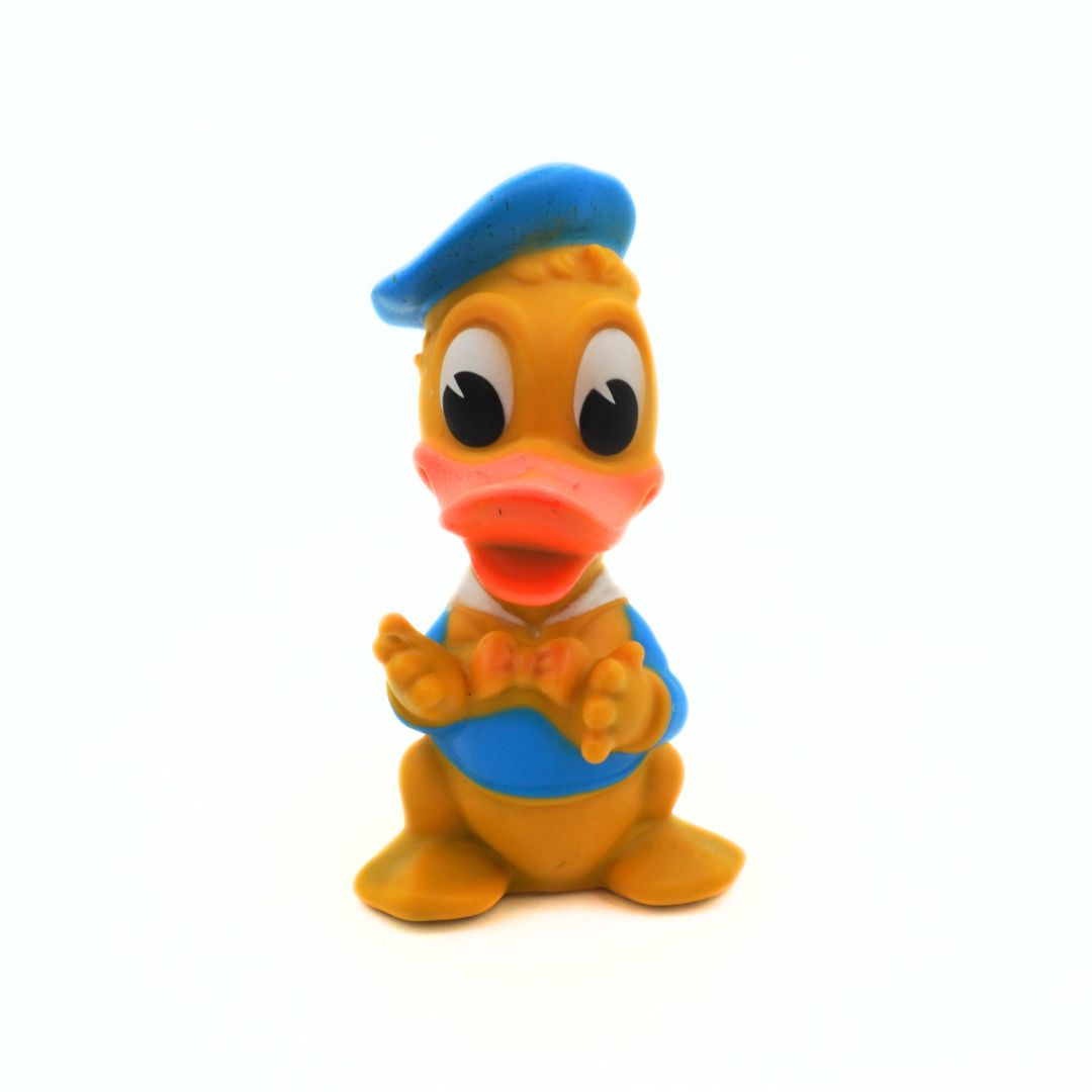 Toy duck figure with a blue hat and bow tie on a white background