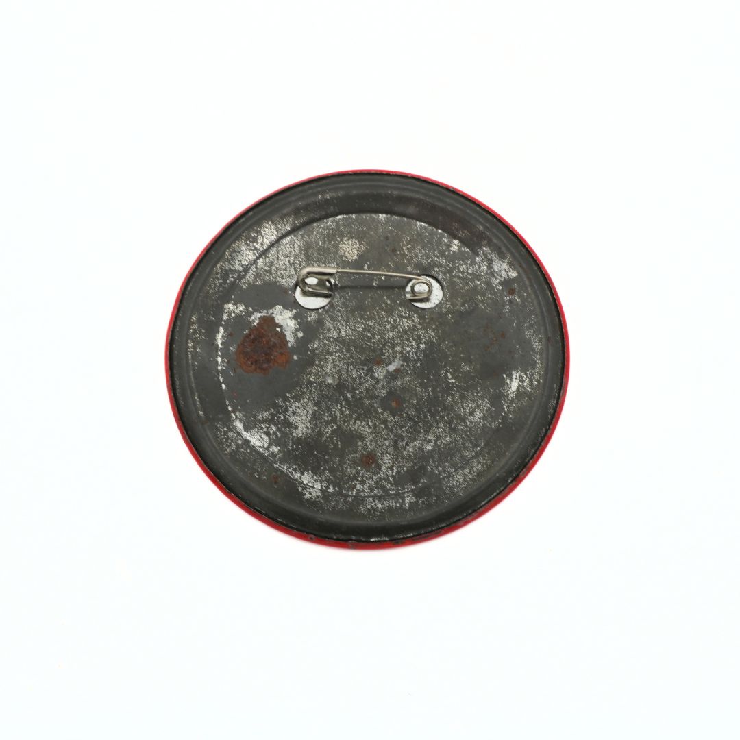 Rust-covered metal button with a red rim on a white background