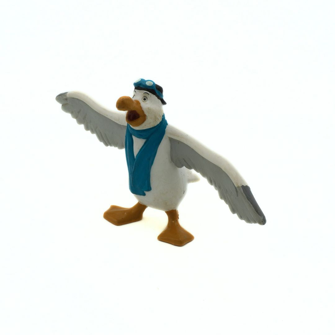 Toy figure of a goose with a blue scarf and hat on a white background