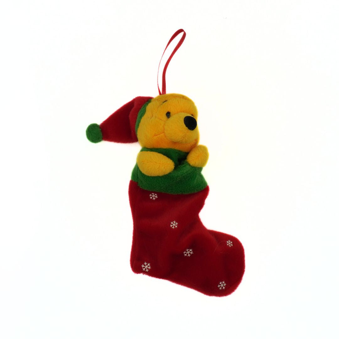 Plush toy of a bear in a red stocking with snowflakes on a white background