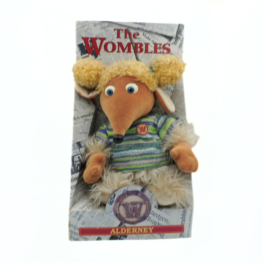 Plush toy resembling a character from 'The Wombles' on a packaging background