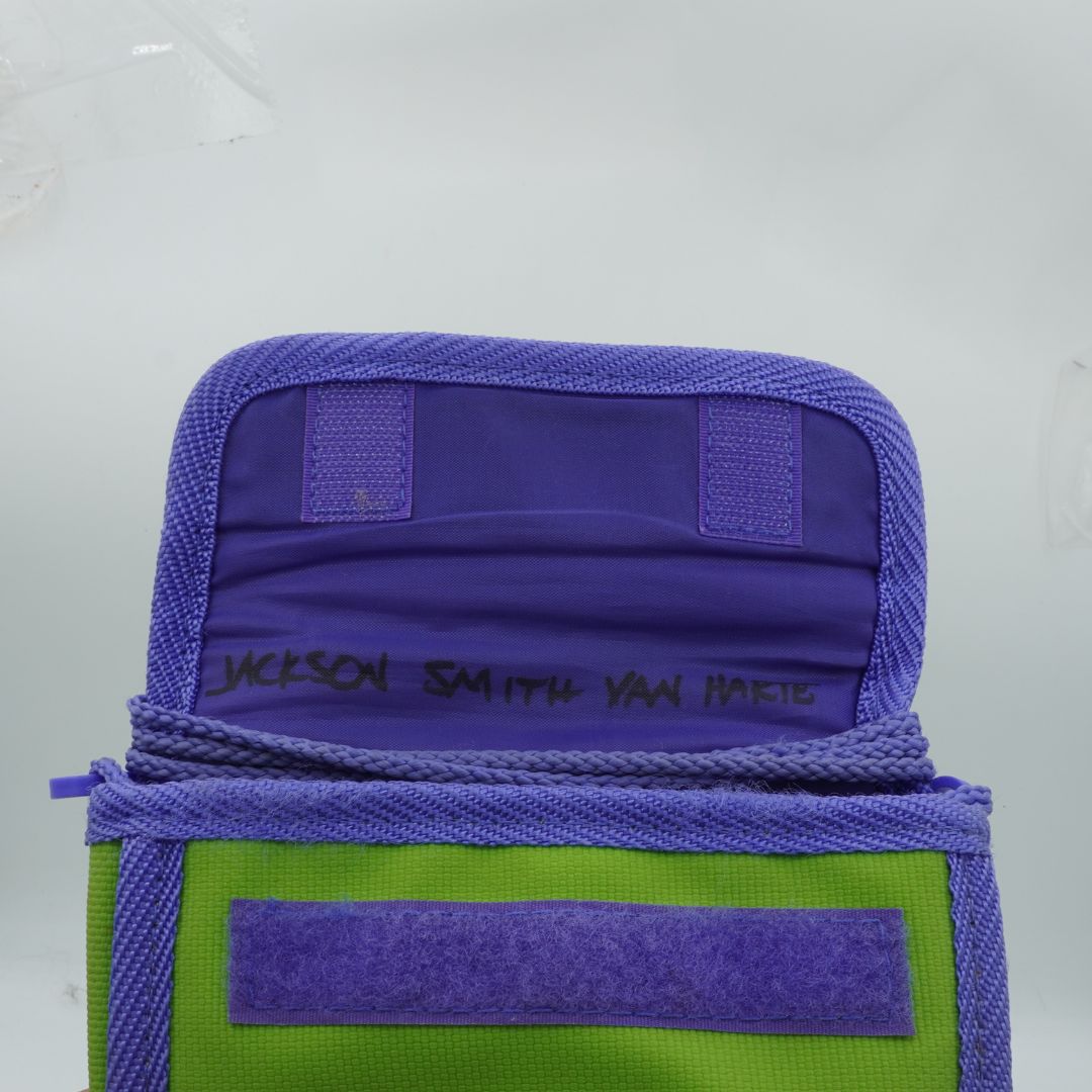 Purple and green bag with 'Jackson Smith Van Heest' branding on a gray background