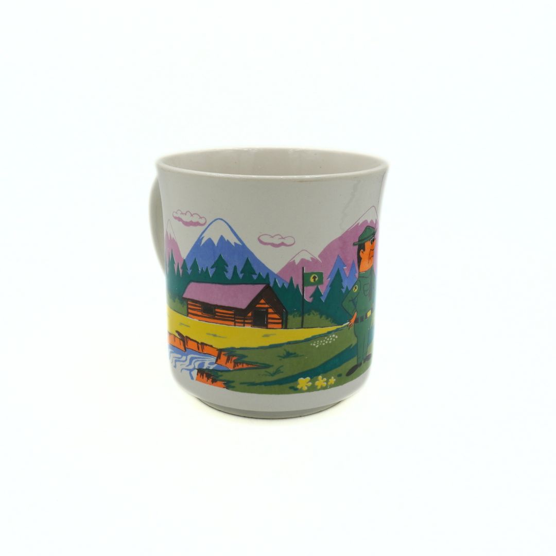 Mug with a colorful landscape design featuring mountains and a cabin on a white background